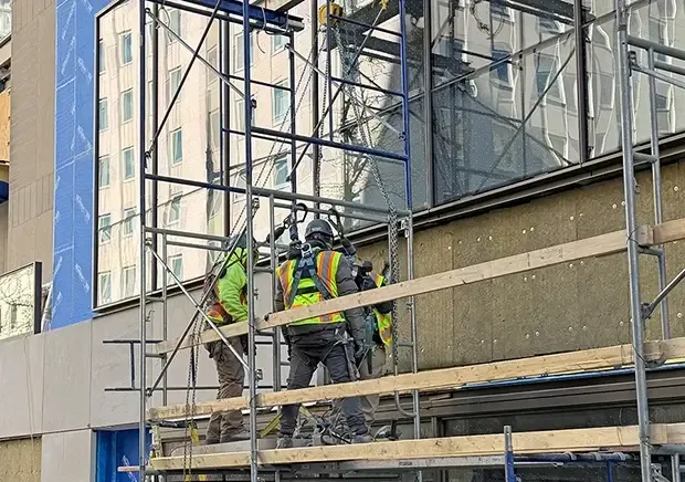 The work addresses an aging building envelope with localized limestone damage, an Altschul Hall roof that required complete replacement, selective parapet deterioration, and deteriorated roof flashings. 