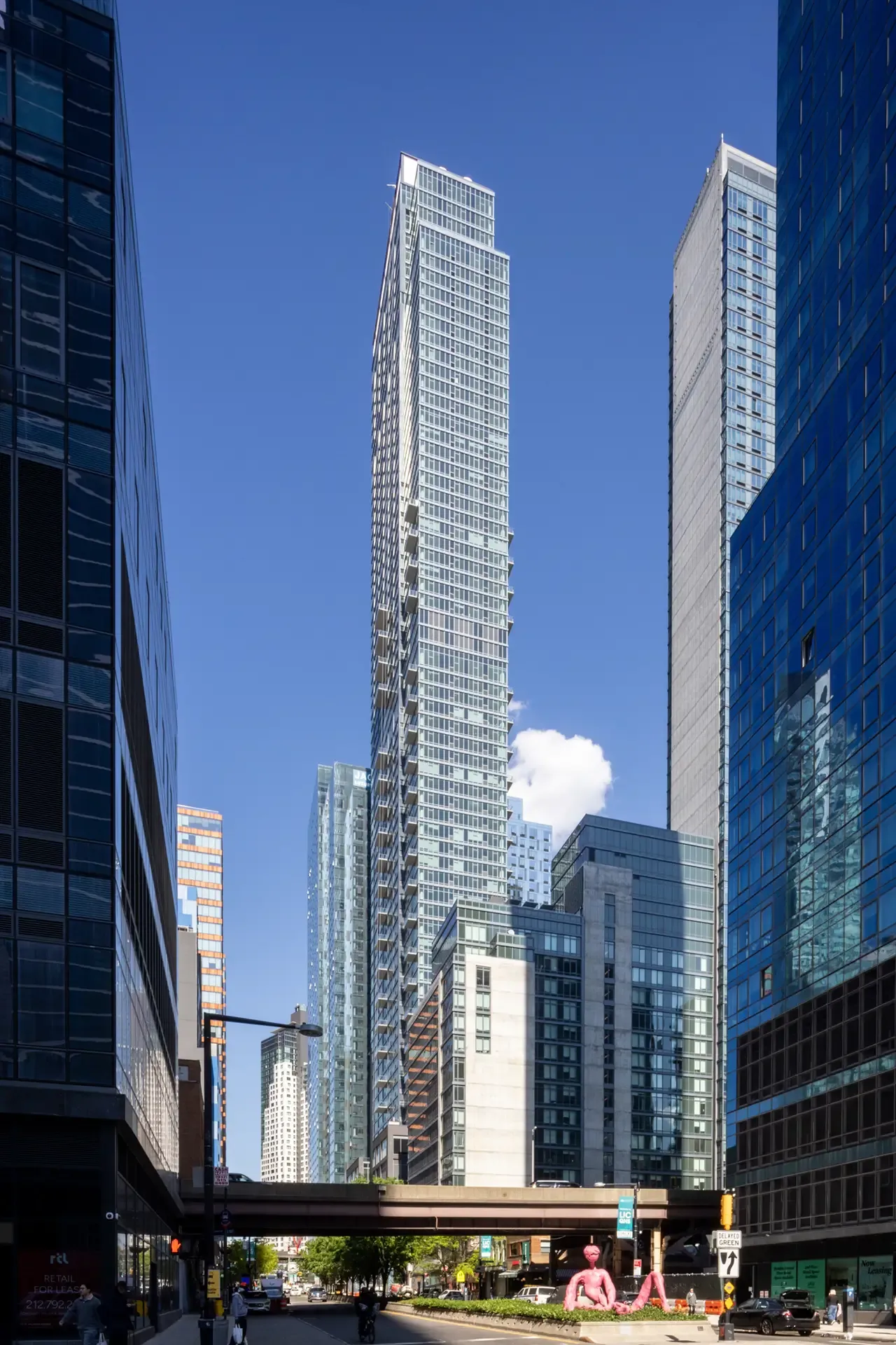 The Orchard’s 69-story residential tower rises above surrounding Long Island City high-rises under a blue sky.