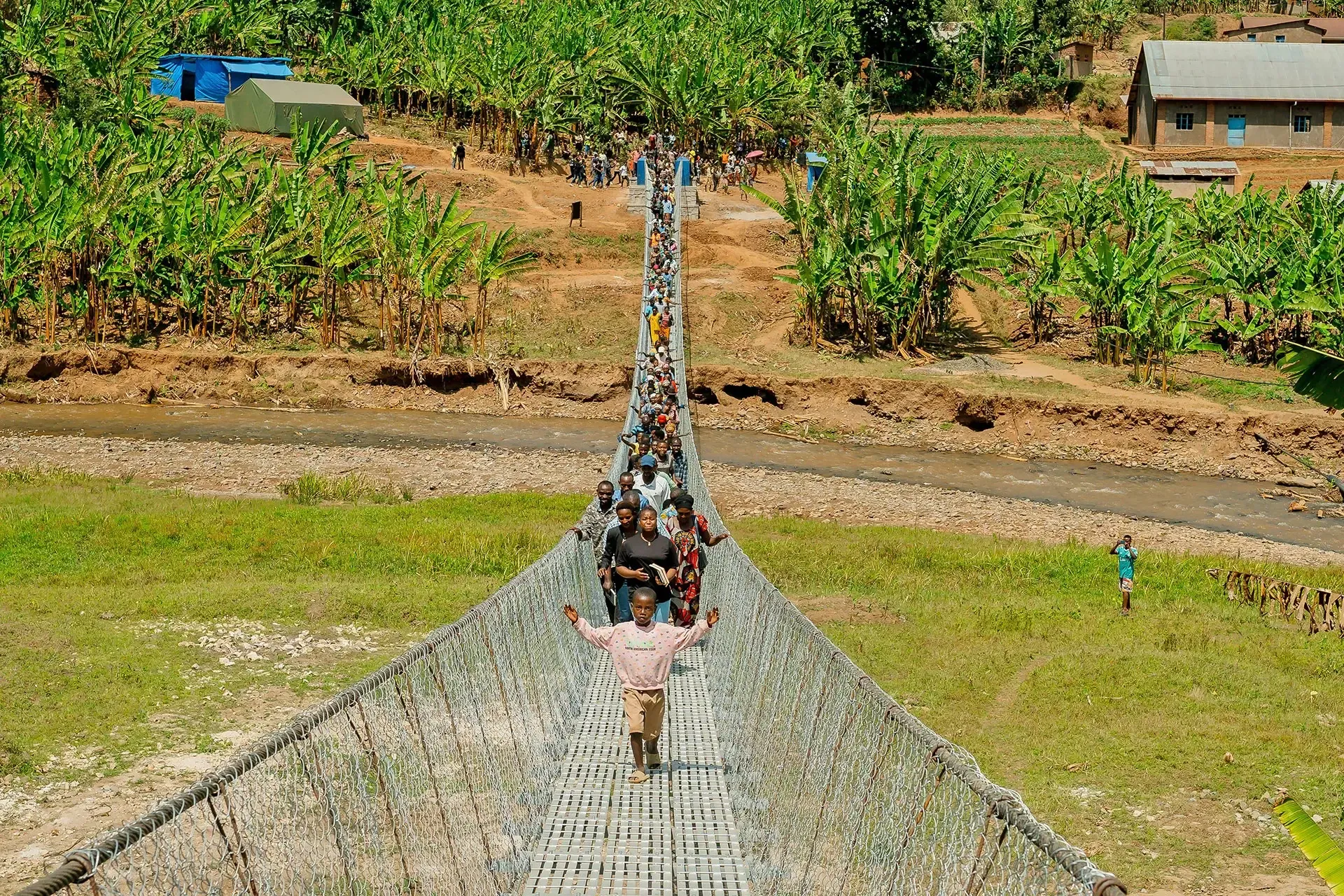 A new suspension trail bridge in rural Rwanda is helping more than 4,430 people safely reach schools, health care, markets, and government services. 
