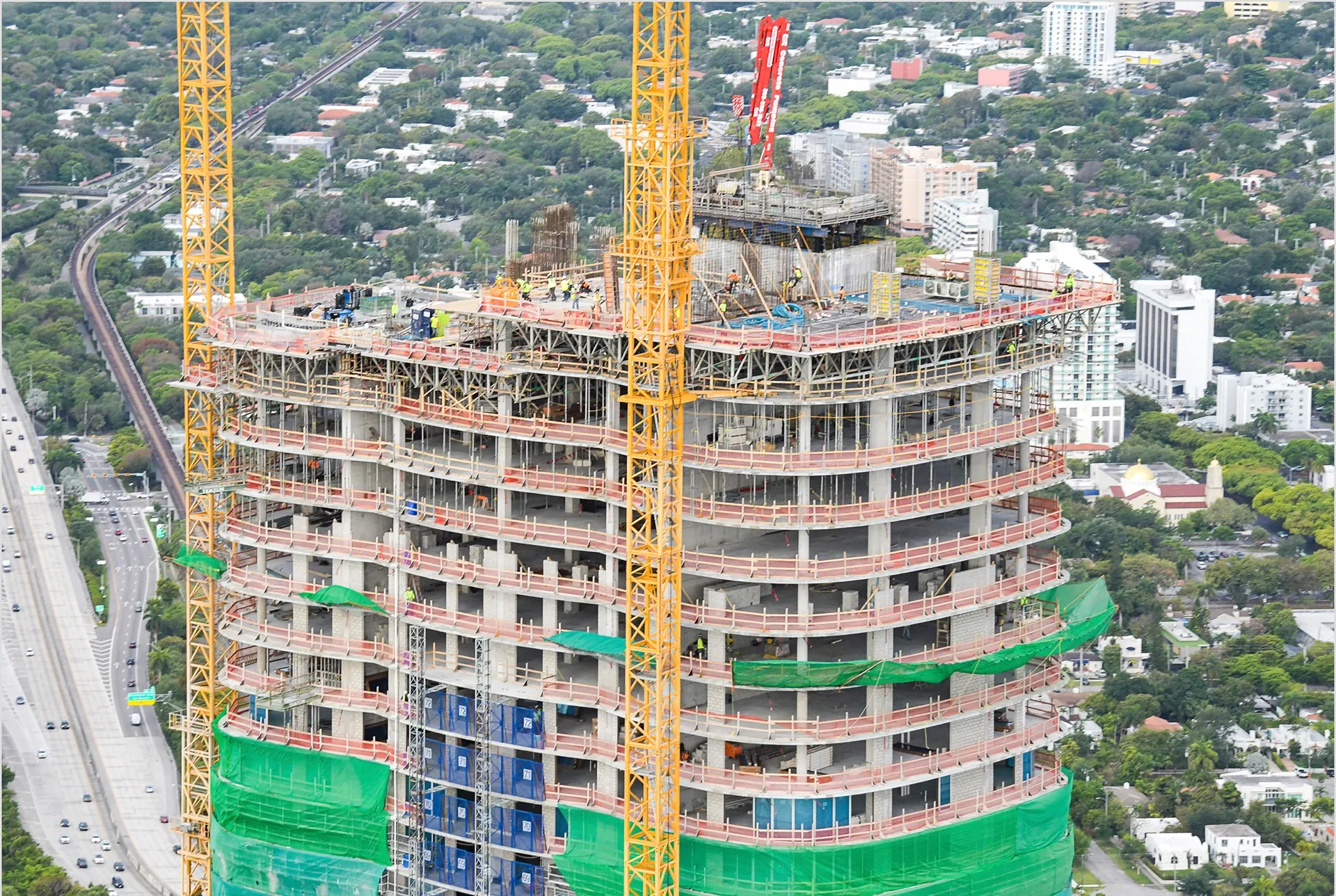 The structural framing consists of mild reinforced concrete columns and shear wall with post-tensioned slabs.